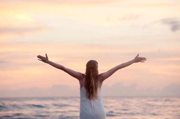 Anti-Inflammatory Support for the Whole Body A woman enjoying a serene sunset on Unawatuna Beach, Sri Lanka, depicting peace and freedom.